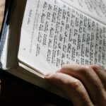 Close-up of a person reading a Hebrew book, highlighting religious study.