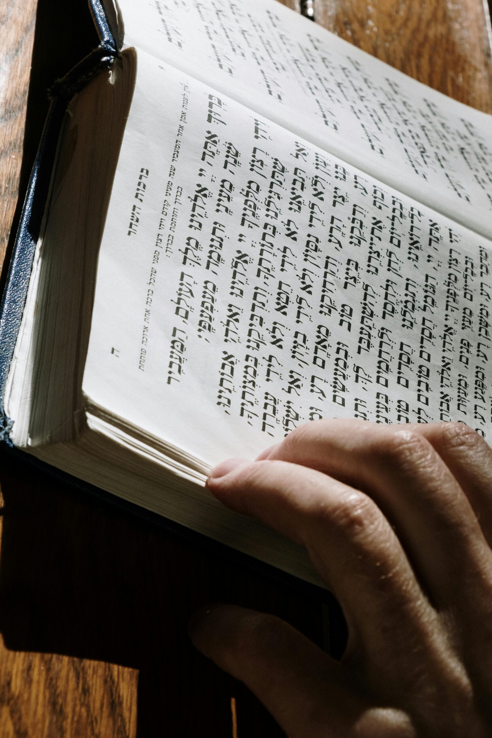 Close-up of a person reading a Hebrew book, highlighting religious study.